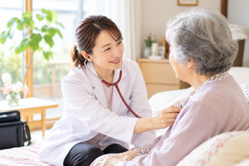 女性医師が高齢患者の自宅を訪問し、聴診器で診察している様子